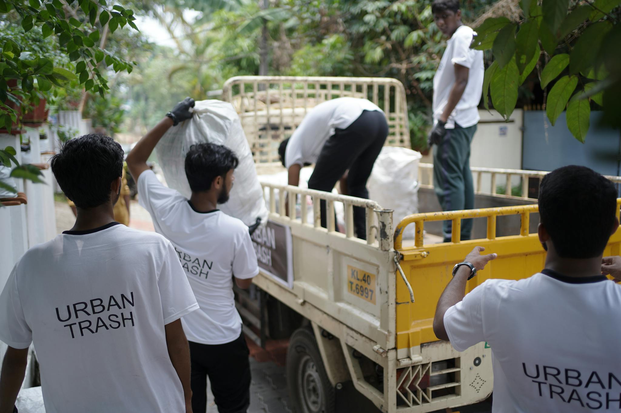 Men Managing Urban Waste Loading Trash Into